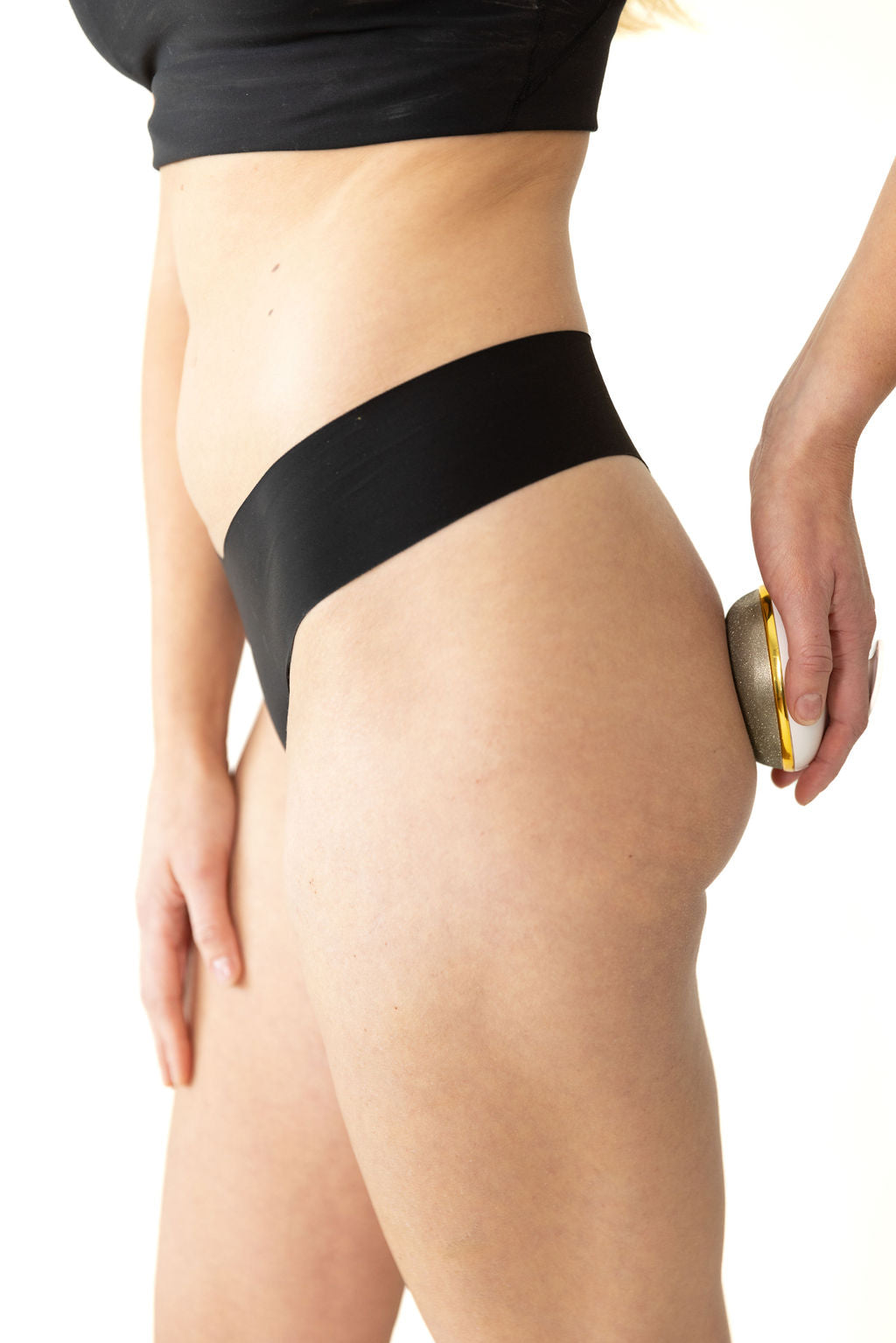 Woman wearing underwear using the FirmaGlow to exfoliate her butt